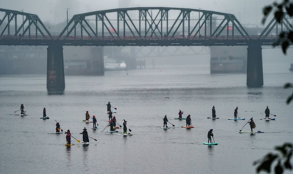 Hundreds of witches clad in black, along with some warlocks and sorcerers, took to the Willamette River Saturday, Oct. 29, 2022, wielding paddles instead of broomsticks, and conjured hocus pocus for the fifth annual Portland Stand Up Paddleboard Witches on the Willamette, also known as SUP WOW.